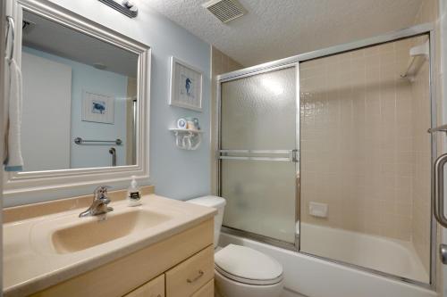 a bathroom with a sink and a shower and a toilet at Oceanfront Ormond Beach Condo Community Perks! in Ormond Beach