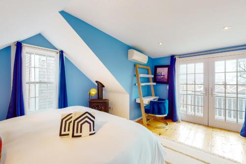 Cette chambre bleue comprend un lit et une échelle. dans l'établissement Picabu Beach, à Provincetown