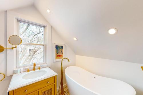 La salle de bains blanche est pourvue d'une baignoire et d'un lavabo. dans l'établissement Picabu Beach, à Provincetown