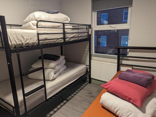 Hostel Rooms In Camden في لندن: غرفة بسريرين بطابقين ونافذة