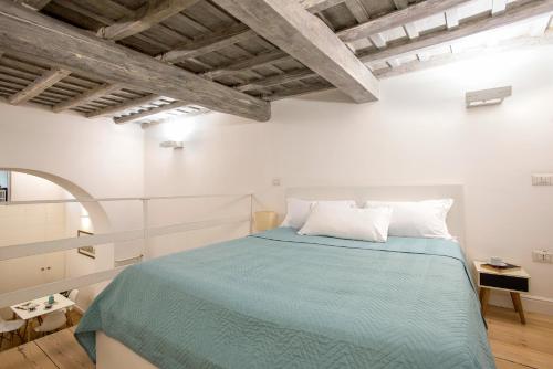 ローマにあるHolidays Teatro Paceの白い部屋に緑のベッドが備わるベッドルーム1室