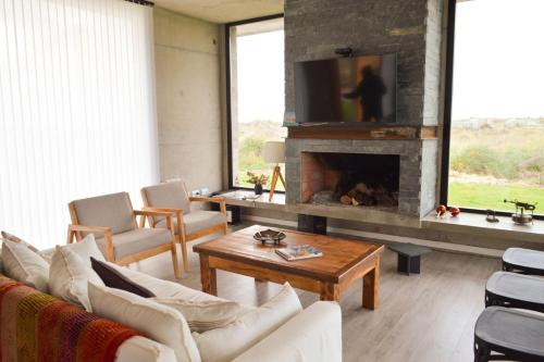 sala de estar con sofá y chimenea en Rincon de Tigre, Mar de las Pampas en el Balneario Mar Azul