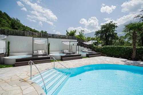 a house with a swimming pool and a patio at Preidlhof Luxury Dolce Vita Resort in Naturno