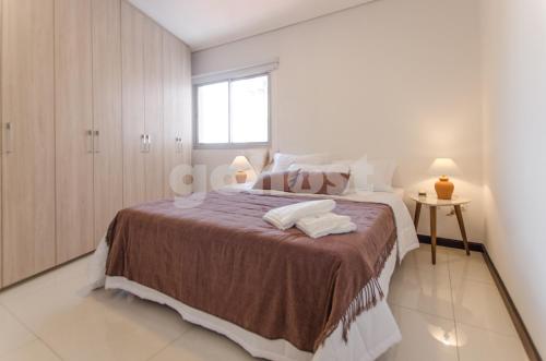ein Schlafzimmer mit einem großen Bett und einem Fenster in der Unterkunft Comfy Villa Morra Apt in Asunción