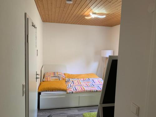 ein kleines Schlafzimmer mit einem Bett mit einer gelben Decke in der Unterkunft Apartment im Herrenwäldchen in Brombachtal