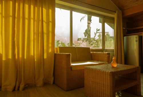 ein Wohnzimmer mit einem Stuhl und einem Fenster in der Unterkunft Sailani Lostels in Rishikesh