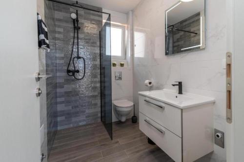 a bathroom with a shower and a sink and a toilet at Villa Helena in Trogir