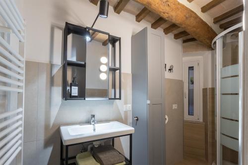 La salle de bains est pourvue d'un lavabo et d'un miroir. dans l'établissement MaRì Modern Flat - Nel cuore verde di Perugia - Posto Auto, à Pérouse