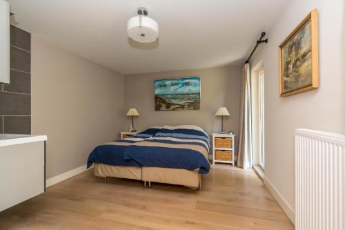 um quarto com uma cama com um cobertor azul em Zoomgronden Renesse em Renesse
