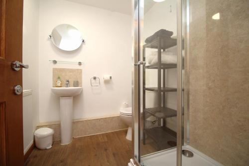 a bathroom with a shower and a toilet and a sink at Countryside Lodge in Peterborough
