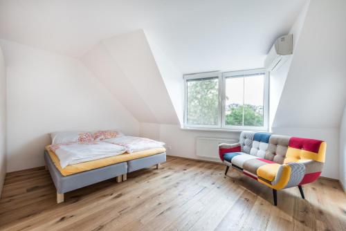 a bedroom with a bed and a couch and a window at Castle Wall Apartment in Bratislava