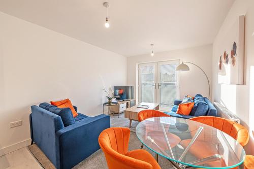a living room with a blue couch and a glass table at Gospel Heights by Guestz in Heswall