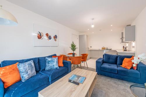 a living room with a blue couch and a table at Gospel Heights by Guestz in Heswall