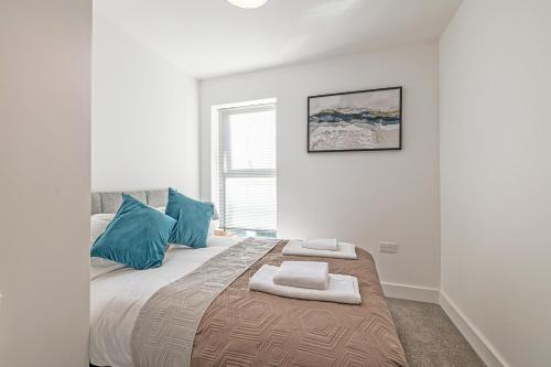 a bedroom with a large bed with blue pillows at Gospel Heights by Guestz in Heswall