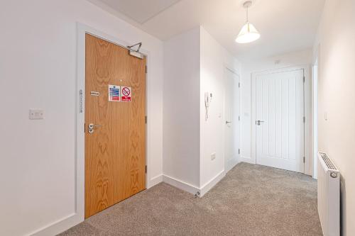 an empty room with a wooden door and a hallway at Gospel Heights by Guestz in Heswall