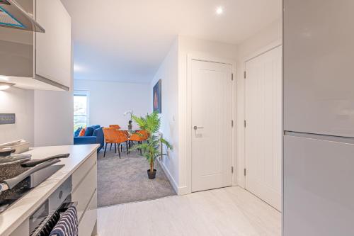 a kitchen with white cabinets and a dining room at Gospel Heights by Guestz in Heswall