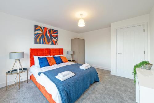 a bedroom with a large bed with an orange headboard at Gospel Heights by Guestz in Heswall