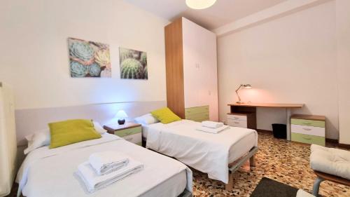 a room with two beds and a desk in it at Flat Barbariga 12 in Trieste