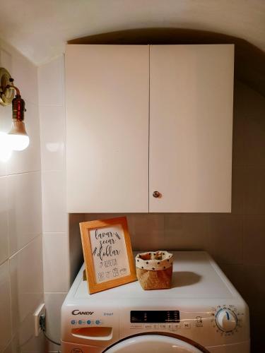 a kitchen with a white cabinet above a washing machine at Casa Rural La Travesía in Bolulla