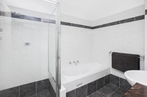 La salle de bains est pourvue d'une douche, d'une baignoire et d'un lavabo. dans l'établissement Riviera 203, à Port Macquarie