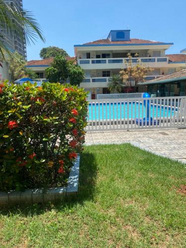 a blue fence in front of a building with flowers at Quintal do forte in Praia Grande