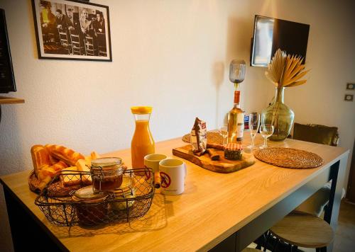 een tafel met brood en wijnglazen en flessen bij Résidence Le SUNSET Marseillan-plage, entre mer et lagune de Thau, étape vélo, famille, couple, VRP, toutou admis, jardin, parking privé gratuit, vélos, Clim, WIFI fibre gratuite, commodités, plage et piste cyclable à proximité, 6 couchages nous contacter in Marseillan
