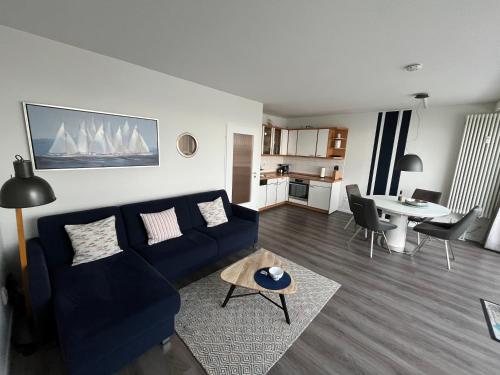 ein Wohnzimmer mit einem blauen Sofa und einem Tisch in der Unterkunft Ferienwohnung Fördedeck in Kiel