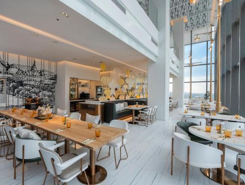 a restaurant with tables and chairs and a kitchen at INNSiDE by Meliá Bangkok Sukhumvit in Bangkok