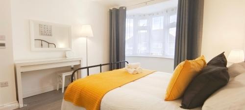 ein Schlafzimmer mit einem Bett mit gelber Bettwäsche und einem Kamin in der Unterkunft Woodfield apartment in The Hyde