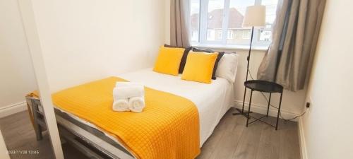a bedroom with a bed with yellow sheets and yellow pillows at Woodfield apartment in The Hyde