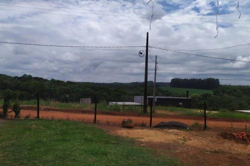 een onverharde weg met een hek naast een veld bij Casa para Alugar para Show Rural Cascavel 2024 in Cascavel