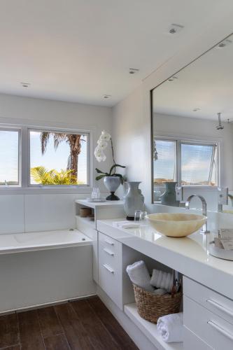 a white bathroom with a sink and a mirror at Casas Brancas Boutique Hotel & Spa in Búzios