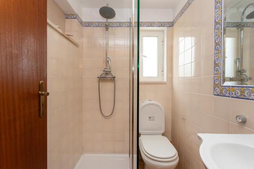 a bathroom with a shower and a toilet and a sink at Le jardin de Teresa in Algoz