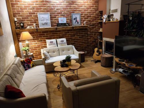 a living room with couches and a brick wall at Dom Kowala in Jankowce