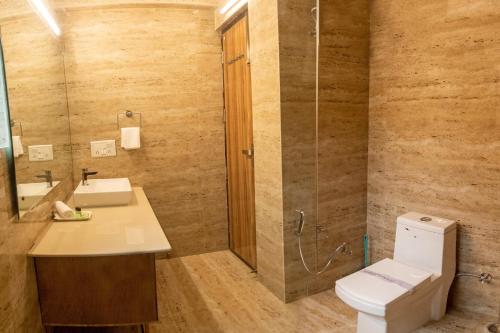 a bathroom with a toilet and a sink and a shower at Allure lake front in Nainital