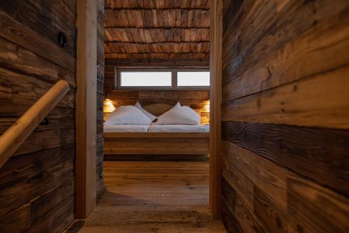 1 dormitorio con 1 cama en una cabaña de madera en Urhof Chalet, en Liesing