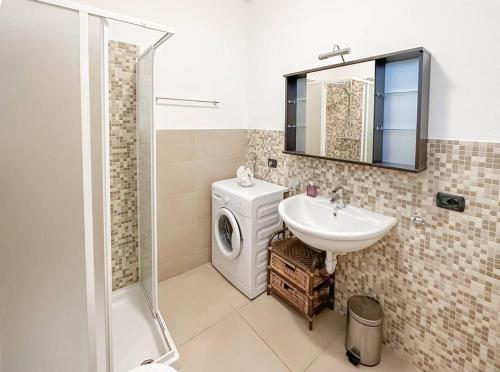 a bathroom with a washing machine and a sink at BELLANOOTJE by Design Studio in Bellano