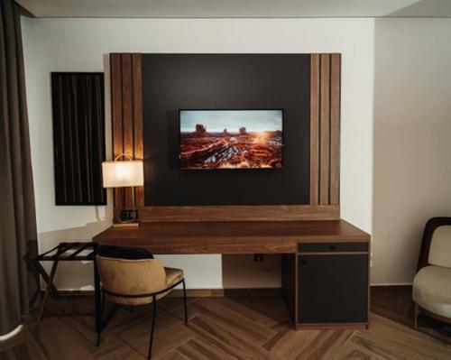 a room with a desk with a television on the wall at City Hotel by Waves in Kenitra