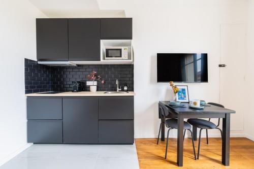 - une cuisine avec une table et un four micro-ondes dans l'établissement Imhost -Élégant appt Tolbiac 4 pers, à Paris