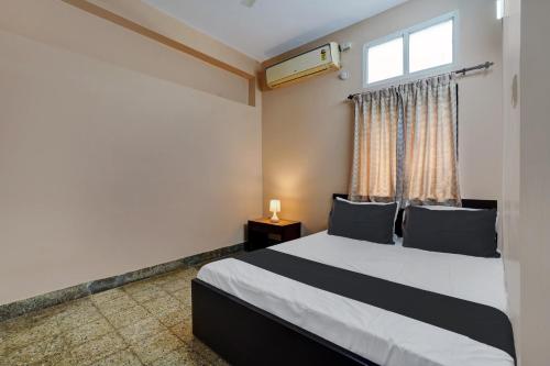 a bedroom with a large bed and a window at SPOT ON Benaka Delux Lodging & Delux Rooms in Bangalore