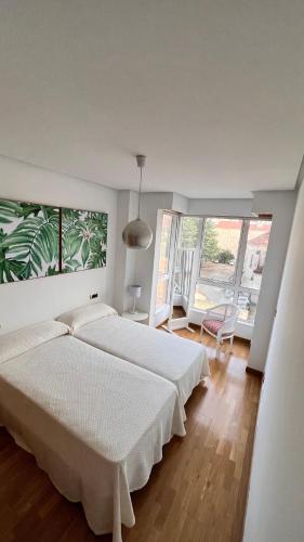 a bedroom with two beds and a large window at Apartamentos San Martin Ourense Centro 2 in Ourense