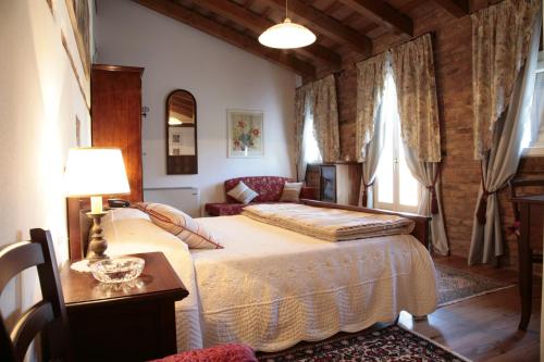 a bedroom with a bed and a table with a lamp at Villa Casa Country in Bovolenta