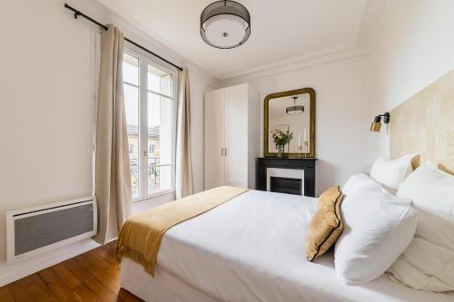 une chambre blanche avec un grand lit et une fenêtre dans l'établissement Imhost -Élégant appt Tolbiac 4 pers, à Paris