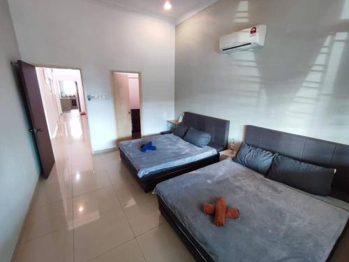 un soggiorno con 2 letti e un divano di Sayang-Sayang Homestay $CRAZY OFFER$ 4R2B a Batu Pahat