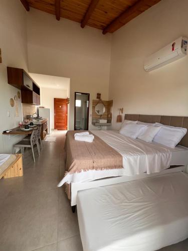 a large bedroom with two beds and a kitchen at Flor de Cacto Beach Home in São Miguel do Gostoso