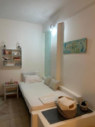 ein kleines Schlafzimmer mit einem weißen Bett in einem Zimmer in der Unterkunft Studio Filareti in Chora, Ios