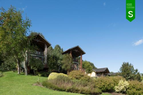 an image of a large house with trees at Hotel y Cabañas Punta Larga - Caja Los Andes in Frutillar