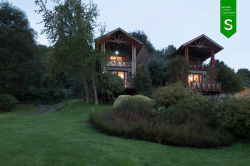 a large house in the middle of a yard at Hotel y Cabañas Punta Larga - Caja Los Andes in Frutillar