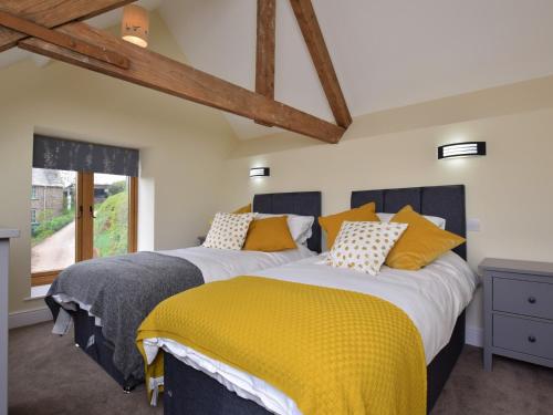 2 bedden in een slaapkamer met een gele deken bij 2 Bed in Chulmleigh 72791 in Coldridge
