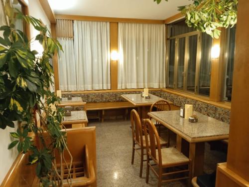 ein Restaurant mit Tischen, Stühlen und Fenstern in der Unterkunft HOTEL BRUSTOLON in Dont